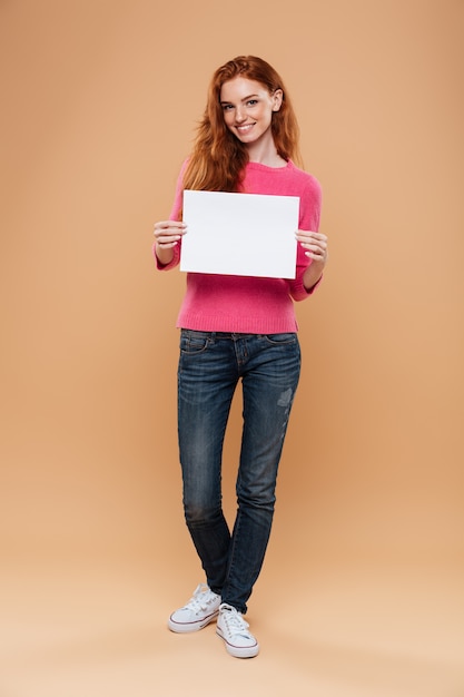 Portrait D'une Jolie Rousse Joyeuse Tenant Une Pancarte Blanche Vierge