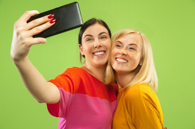 Portrait de jolies filles charmantes dans des tenues décontractées isolées. Copines ou lesbiennes faisant des selfies. Concept de LGBT, égalité, émotions humaines, amour, relation.