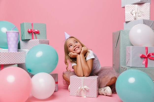 Portrait d'une joyeuse petite fille dans un chapeau d'anniversaire