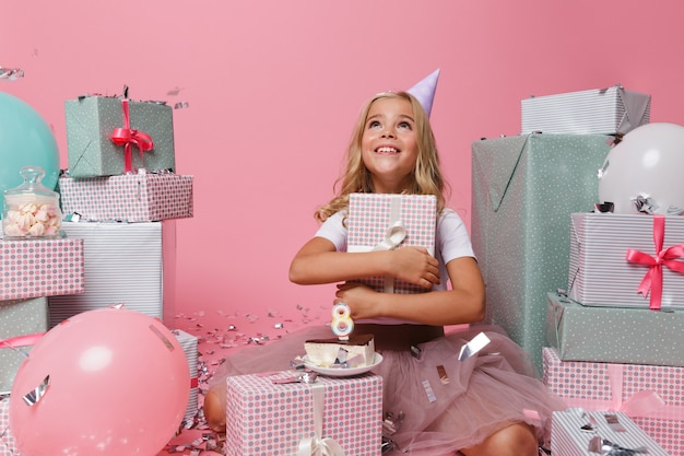 Photo gratuite portrait d'une joyeuse petite fille dans un chapeau d'anniversaire