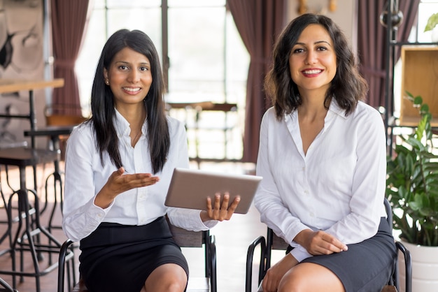 Portrait de joyeux collègues féminines multiethniques réunion dans le salon.