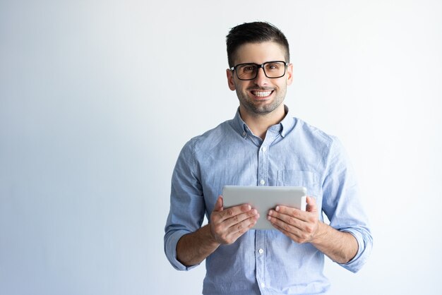 Portrait de joyeux utilisateur de tablette excitée portant des lunettes