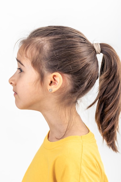 Photo gratuite portrait latéral d'une fille en chemise jaune isolée sur fond blanc