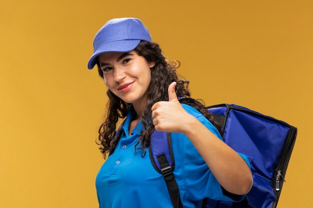 Portrait de livreur féminin montrant les pouces vers le haut