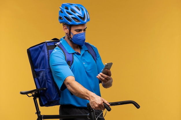 Portrait de livreur avec smartphone et vélo