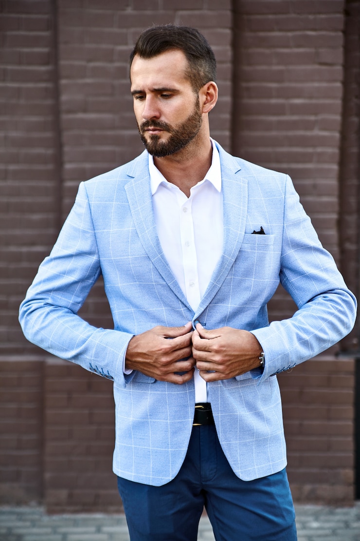 Photo gratuit portrait de mannequin homme d'affaires sexy beau vêtu d'un élégant costume bleu posant sur fond de rue. métrosexuel