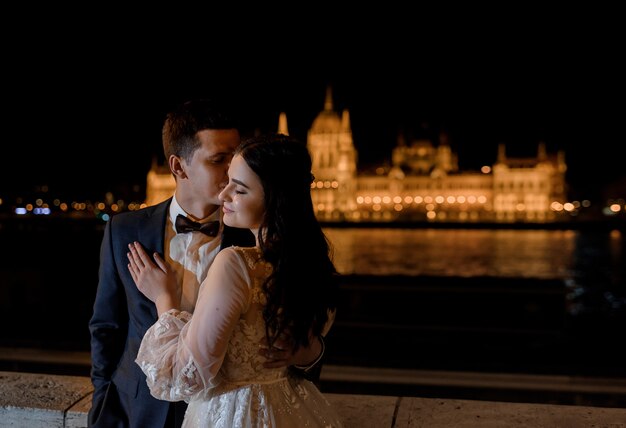 Portrait de marié et mariée avec belle vue sur la ville de nuit, lune de miel de mariage dans l'Europe architecturale
