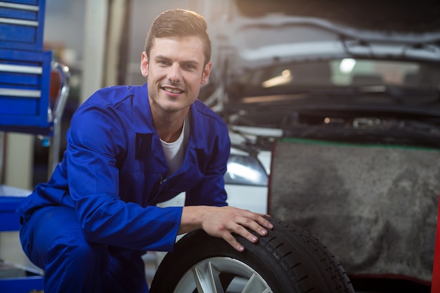 Portrait de mécanicien avec un pneu