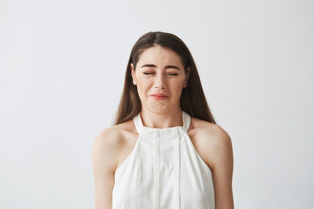 Portrait de méchante jeune fille brune faisant la grimace.