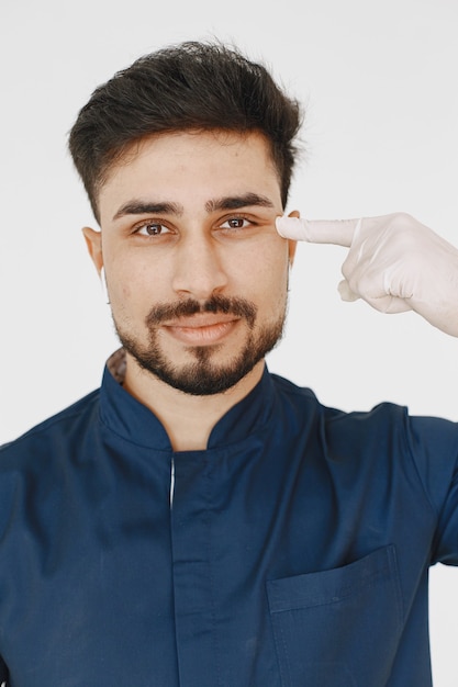 Un portrait d'un médecin posant contre un mur blanc