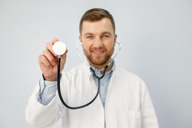 Portrait d'un médecin de sexe masculin regardant la caméra tenant un stéthoscope
