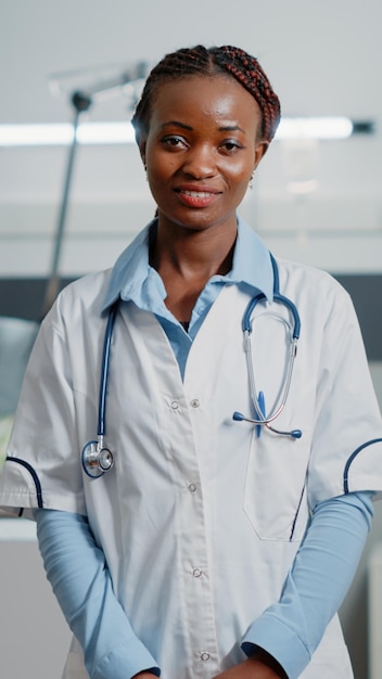 Photo gratuite portrait d'un médecin spécialiste avec blouse blanche et stéthoscope debout dans la salle d'hôpital. femme travaillant comme médecin pour aider les personnes malades, regardant la caméra. médecin de santé