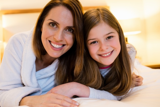 Portrait de la mère et fille couchée sur le lit