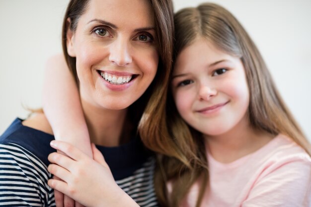 Portrait de la mère et la fille embrassant dans la salle de r