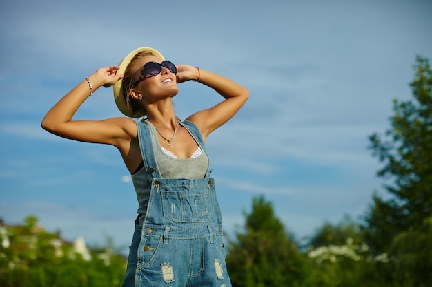 portrait, de, mignon, drôle, jeune, élégant, sourire, femme femme, modèle femme, dans, désinvolte, moderne, tissu, à, parfait, bain de soleil, corps, dehors, dans parc, dans, chapeau