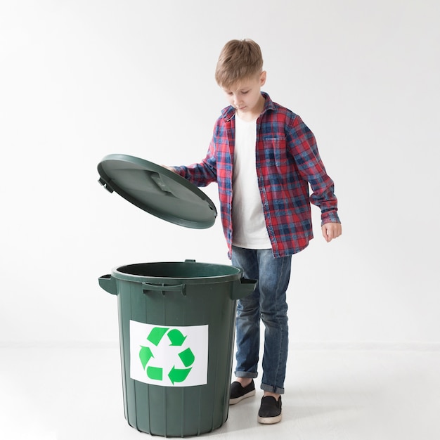 Portrait de mignon jeune garçon heureux de recycler