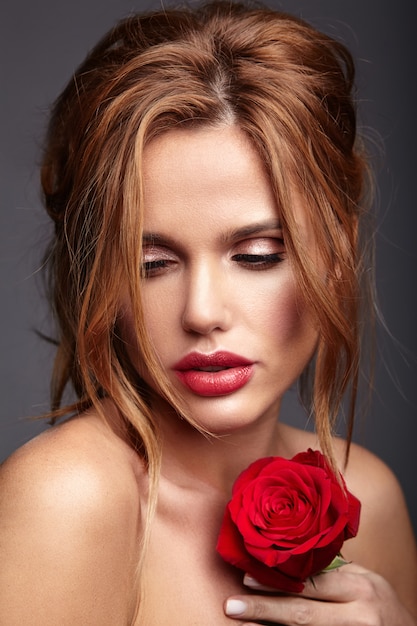 Portrait de mode beauté du jeune mannequin femme blonde avec un maquillage naturel et une peau parfaite avec une belle rose posant