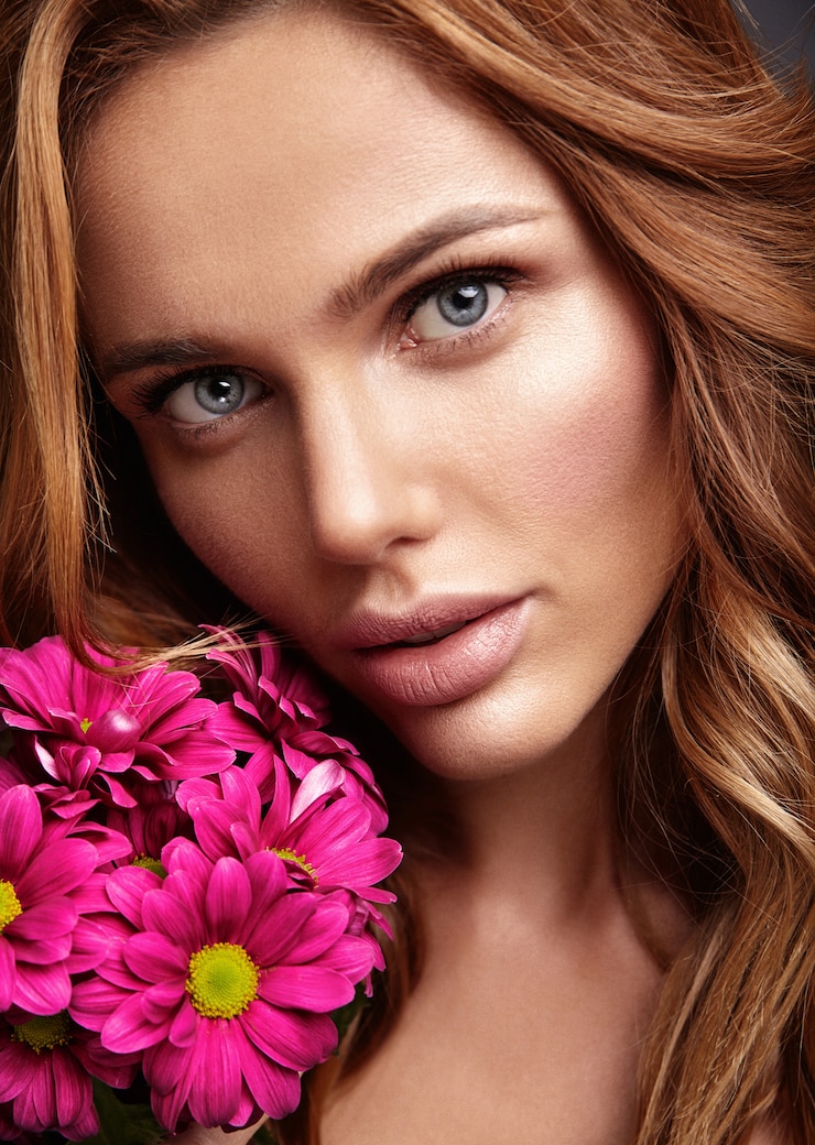 Photo gratuit portrait de mode de beauté du jeune mannequin femme blonde avec un maquillage naturel et une peau parfaite avec une fleur de chrysanthème сrimson brillant posant