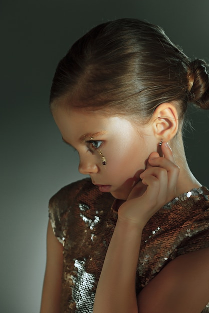 Le portrait de mode de la belle jeune fille préadolescente au studio