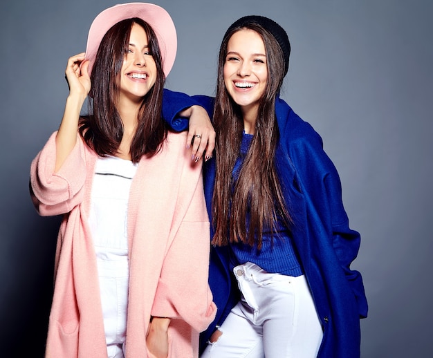 portrait de mode de deux modèles de femmes brune souriante en été pardessus hipster décontracté posant sur gris