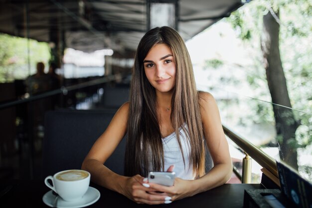 Portrait de mode en plein air de la belle jeune fille buvant du thé café seul