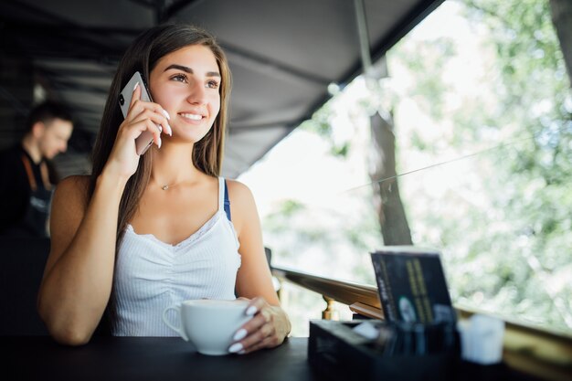 Portrait de mode en plein air de la belle jeune fille buvant du thé café