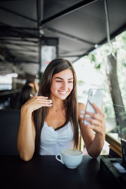 Portrait de mode en plein air de la belle jeune fille buvant du thé café