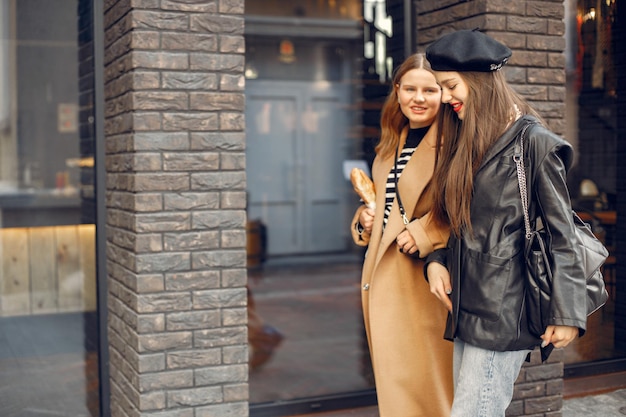 Portrait de mode en plein air de deux belles jeunes femmes portant des vêtements élégants à la mode. Jeunes filles posant dans la rue de la ville européenne. Filles marchant dans la rue.