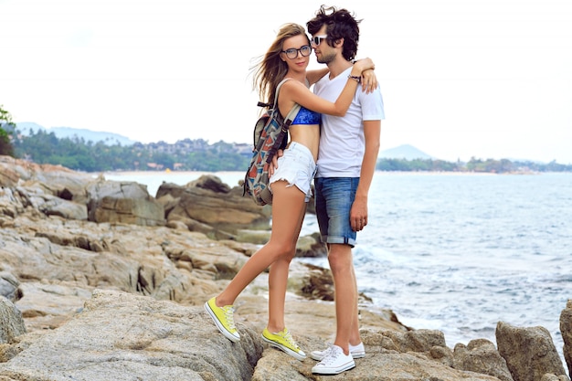 Portrait de mode de vie en plein air de jeune beau couple amoureux posant et s'amusant sur la jolie plage de pierre, couleurs douces aux tons.