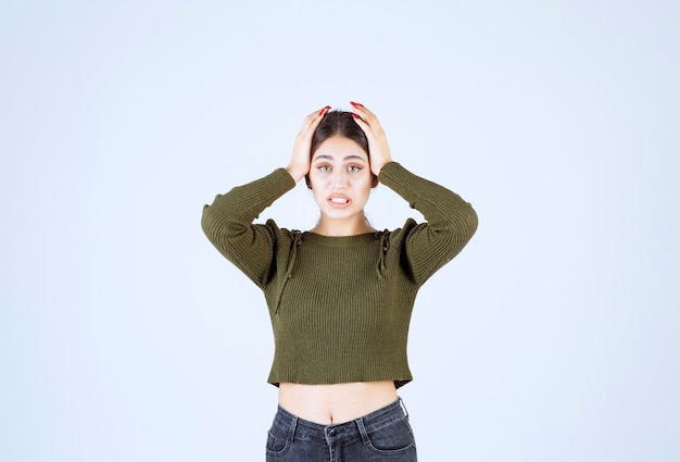 Portrait d'un modèle de belle jeune femme debout et tenant sa tête.