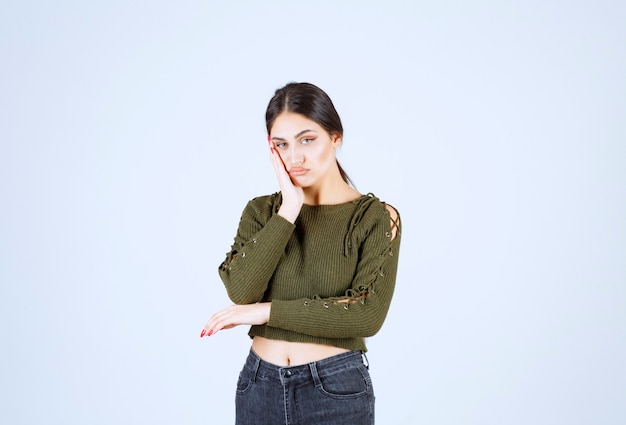 Portrait d'un modèle de belle jeune femme posant joyeusement sur un mur blanc