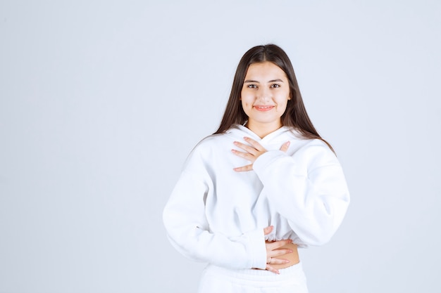 Portrait de modèle de fille posant et posant sur blanc-gris.