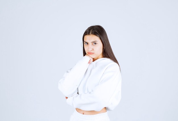 Portrait de modèle de fille posant et posant sur blanc-gris.