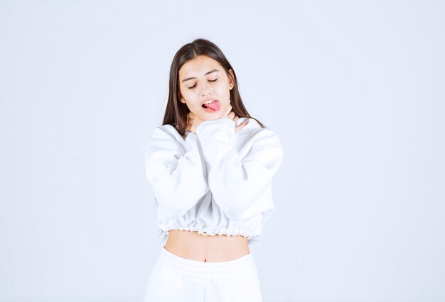 Portrait de modèle de fille posant et posant sur blanc-gris.