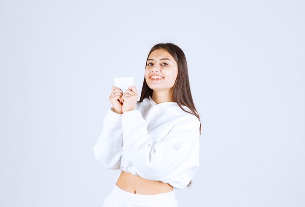 Portrait d'un modèle de jeune fille avec une carte sur fond blanc-gris.