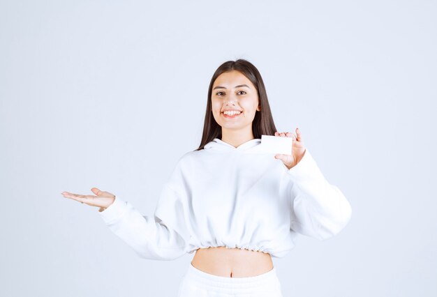 Portrait d'un modèle de jeune fille avec une carte sur fond blanc-gris.