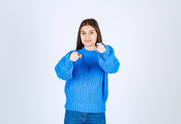 Portrait d'un modèle de jeune fille debout et pointant vers l'avant