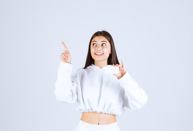 Portrait d'un modèle de jeune fille heureuse avec une carte pointant vers le haut.
