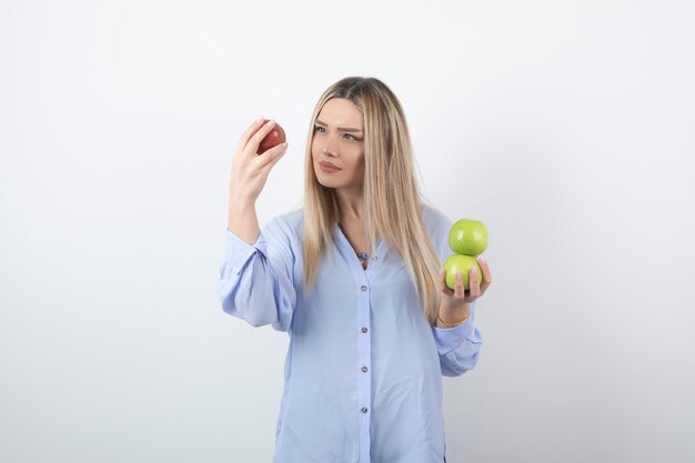 portrait d'un modèle de jolie fille debout et tenant des pommes fraîches.