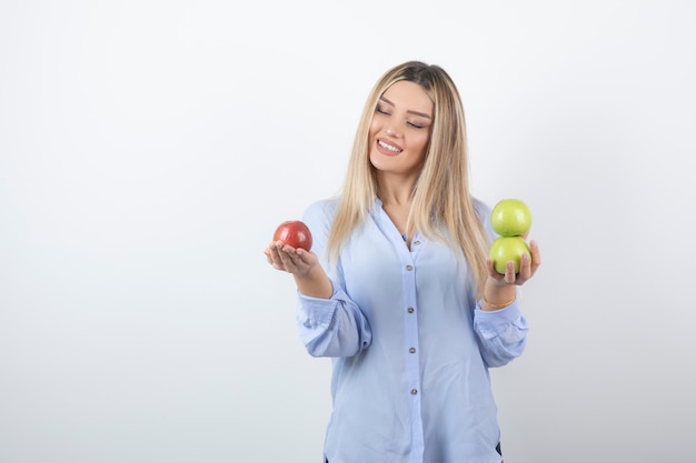 portrait d'un modèle de jolie fille debout et tenant des pommes fraîches.