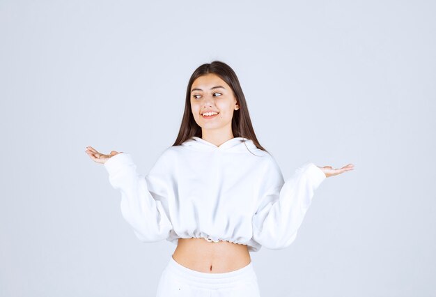 Portrait d'un modèle de jolie jeune fille debout et en détournant les yeux.