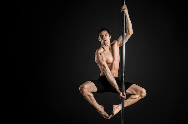 Portrait de modèle masculin effectuant une pole dance