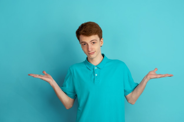 Portrait monochrome de jeune homme sur fond bleu