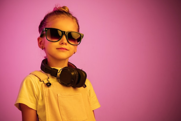 Portrait de néon de jeune fille avec des écouteurs appréciant la musique.