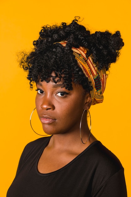 Portrait de noire frisée jeune femme en studio