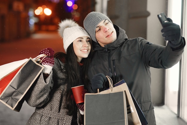 Portrait de nuit en plein air de jeune couple avec des sacs à provisions