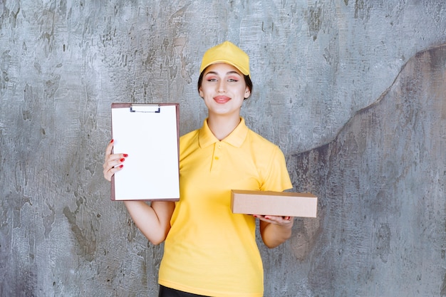 Portrait of female courier holding presse-papiers avec boîte en carton