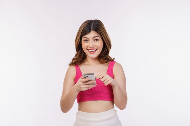 Portrait of happy smiling young woman using mobile phone isolé sur fond blanc