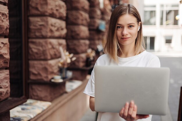 Portrait of smiling woman holding laptop regarder la caméra