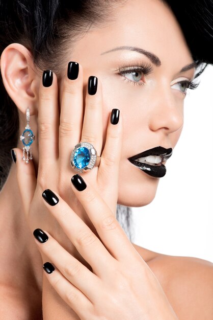 Portrait des ongles, des lèvres et des yeux de femme glamour peints en noir